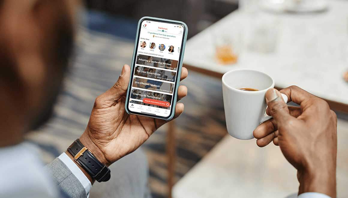 A man looks at TaskHuman app on his phone screen.